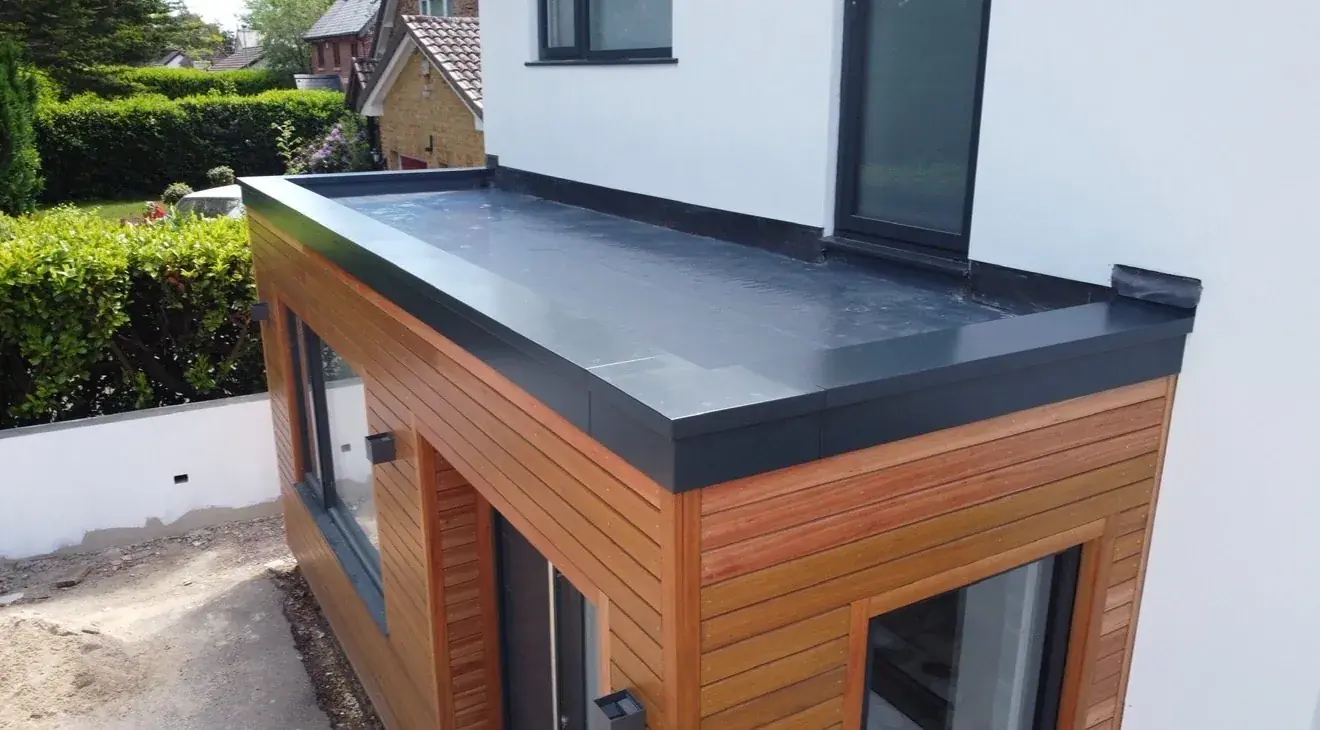 Single ply flat roof on a timber-clad garden room extension